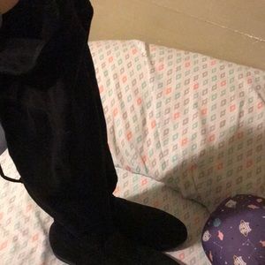 Knee high boots has a zipper and ties in the back